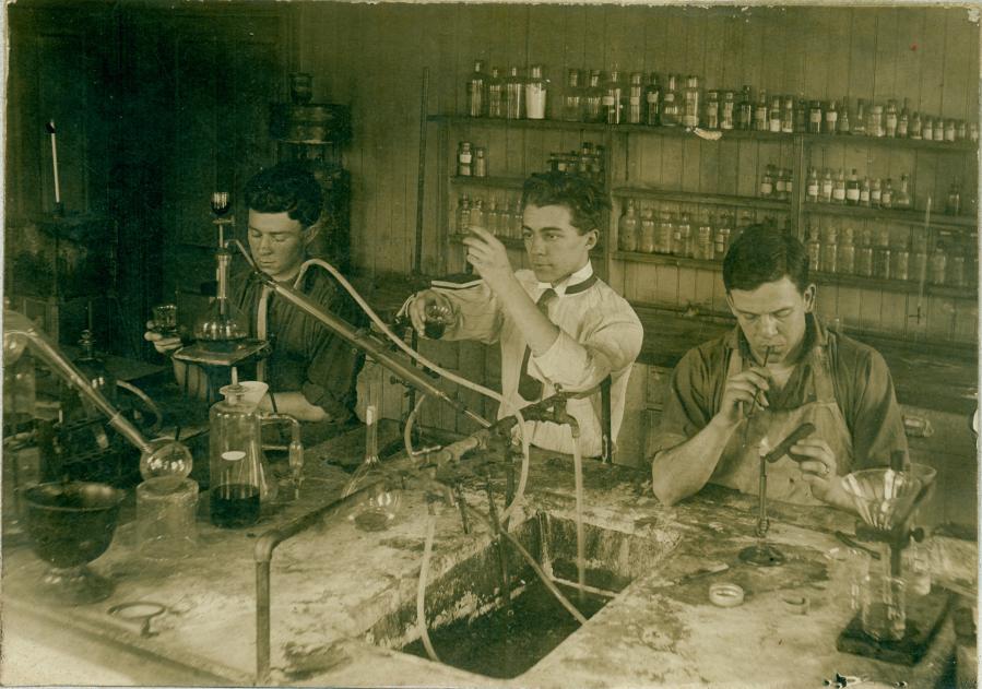 Three students in an early chemistry lab, c. 1900-1912
